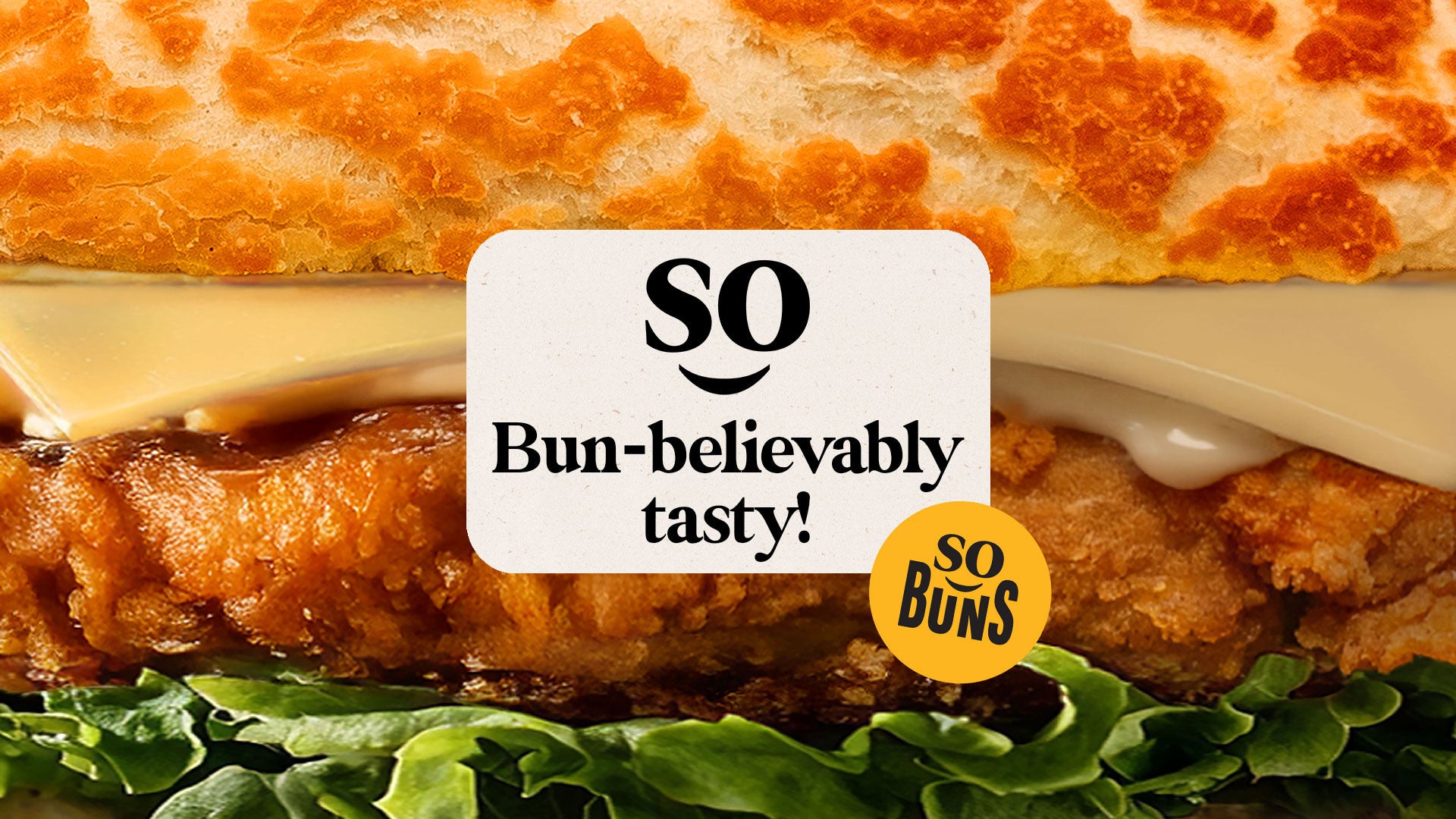 Close-up of a burger with a 'so bun-believably tasty!' sign overlay.